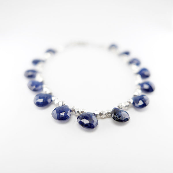 Blue sapphire and silver bracelet with 14 gems beaded with 3 silver beads in between each sapphire.