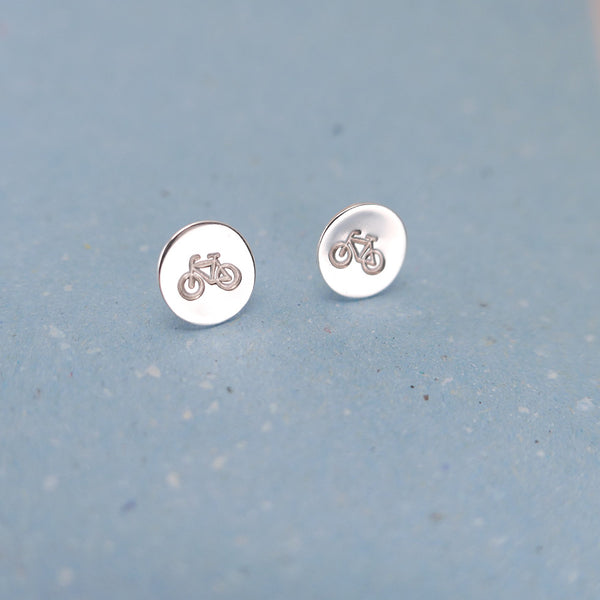 Close up of handmade silver jewelry Sterling silver earrings with stamp of bicycle.