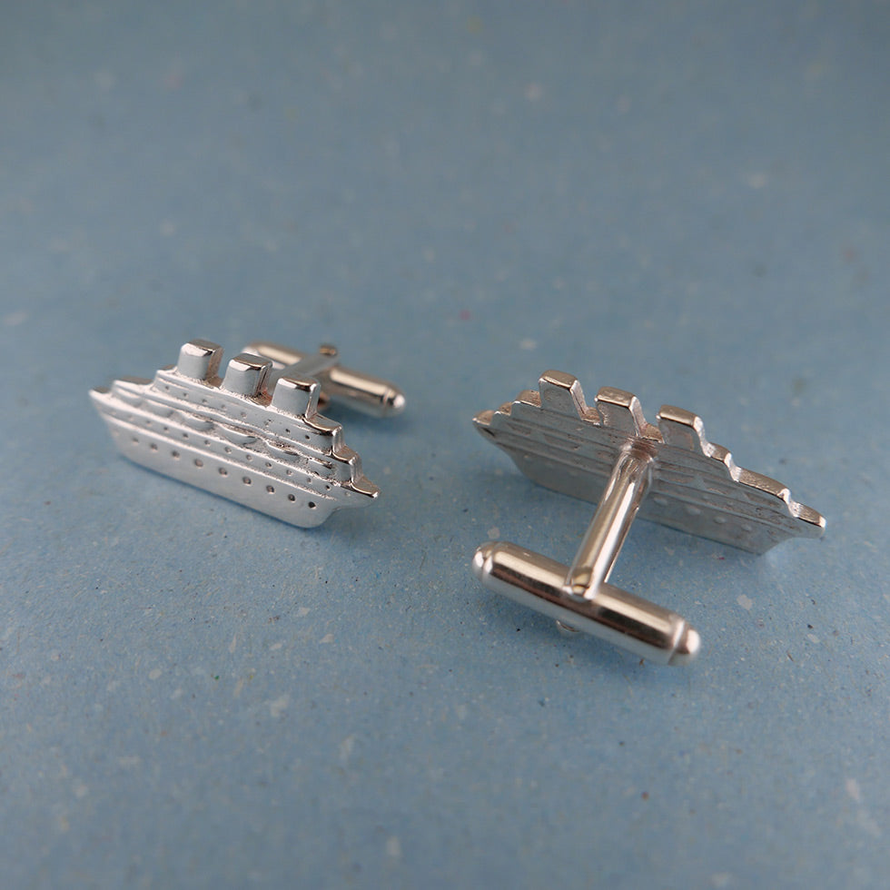 Close up of sterling silver cruise ship cufflinks with one showing the backing clasp.