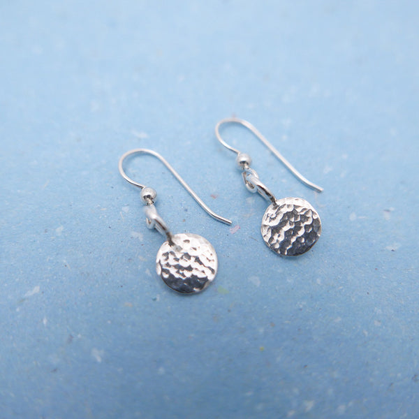 Handmade silver hammered dot hanging earrings side by side.