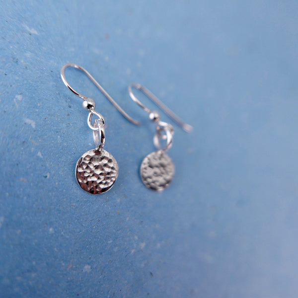 Perspective view of beautiful handmade jewelry hammered circle dot earrings.