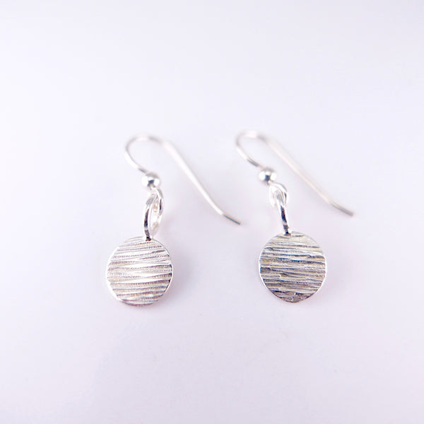 Side by side hammered line silver dot hanging earrings by Granville Island Silversmith jeweler.