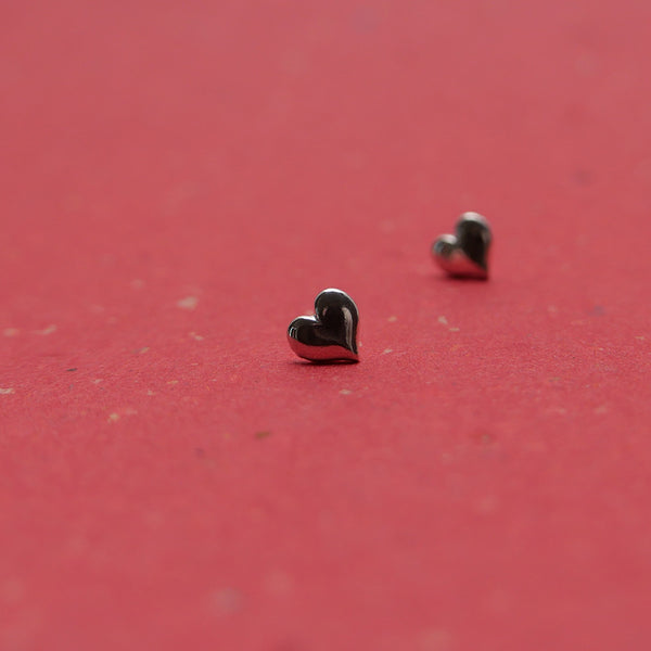 Beautiful silver heart stud earrings with closeup of one.