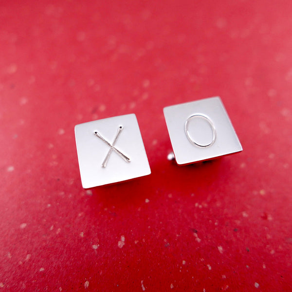 Close up of handmade and hand stamped xo cufflinks.