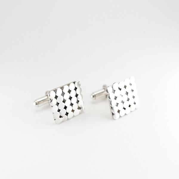 25 silver dots on square cufflinks on angle view.